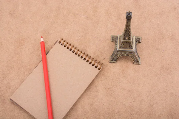 Little model Eiffel Tower, notebook and pencil — Stock Photo, Image