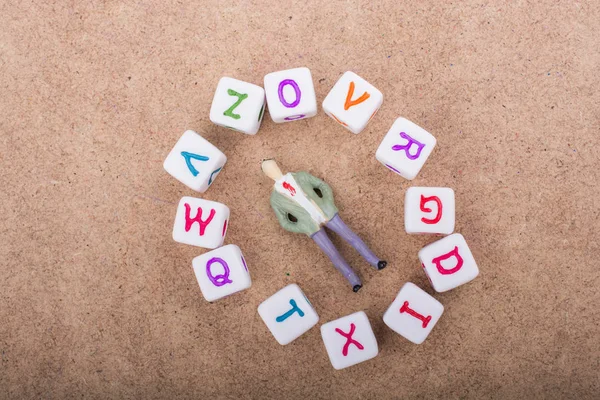 Figurka i kolorowy alfabet kostki z literkami — Zdjęcie stockowe