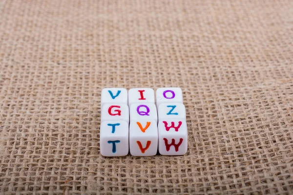 Kostki z literkami alfabetu kolorowe na płótnie — Zdjęcie stockowe