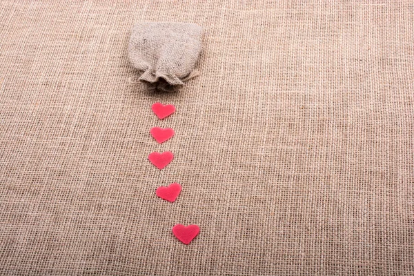 Objetos em forma de coração diante de um saco — Fotografia de Stock