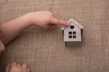 Bir tuval üzerine bir model ev tutan çocuk