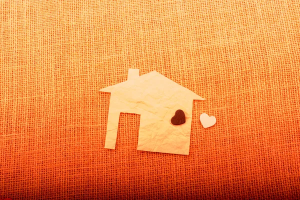 Форма сердца на форме дома вырезанная из бумаги — стоковое фото