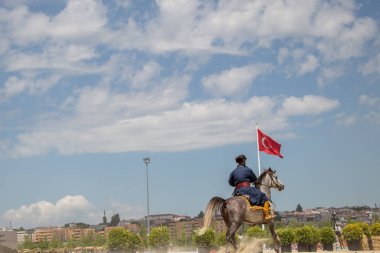 Osmanlı atlısı etnik kıyafetleriyle atına biniyor.