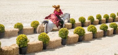 Osmanlı atlısı etnik kıyafetleriyle atına biniyor.
