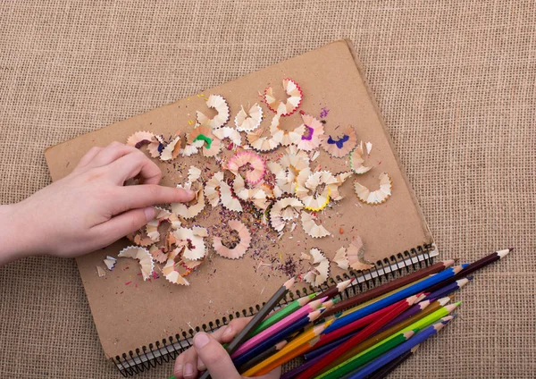 Renkli kalem talaşı ve el izleri.