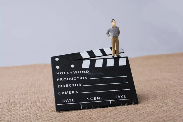 Movie  clapper and a man figurine