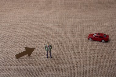 Ok ve bir adam heykelcik ve kırmızı oyuncak araba 