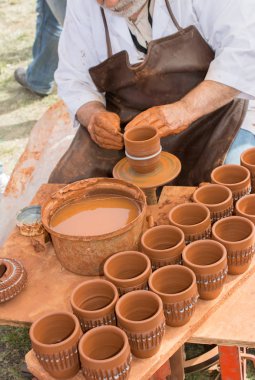 Potter 'ın elleri çömleğin kilini şekillendiriyor.