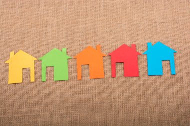 Tuvalin arka planında renkli kağıttan kesilmiş küçük bir ev şekli