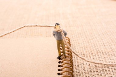 Heykelcik adam boynuna bir ip ile