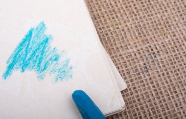 Bir defter üzerinde yerleştirilen mavi renk pastel boya