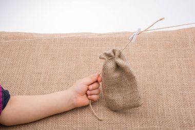 Küçük çuval ketenden boş tutan el