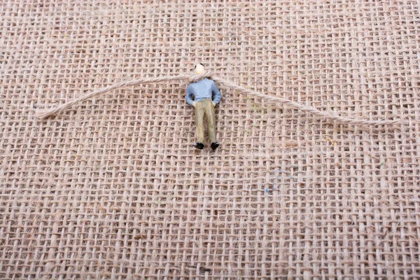 Heykelcik adam boynuna bir ip ile