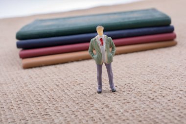 Adam heykelcik ayakta tuval üzerine küçük kitap yanında