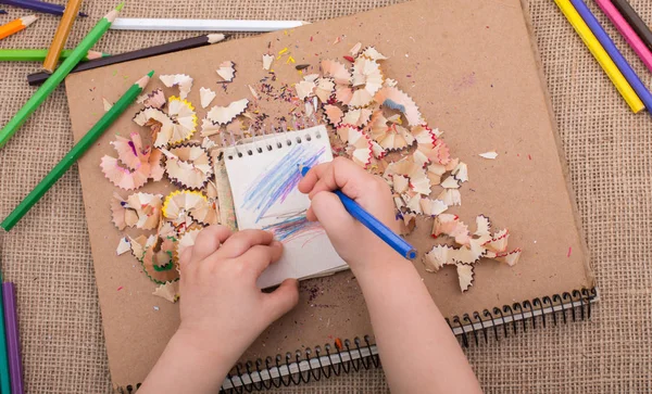 Hand hält einen Farbstift auf Spiralheften — Stockfoto