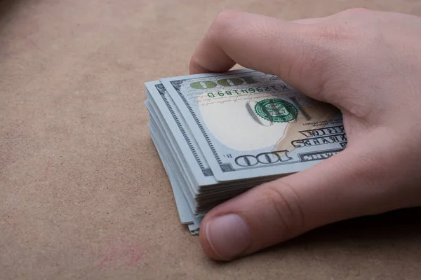 Hand holding banknote bundle of US dollar in hand