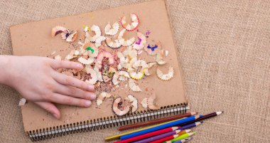 Kahverengi bir arka plan üzerine yerleştirilen renkli kalemler