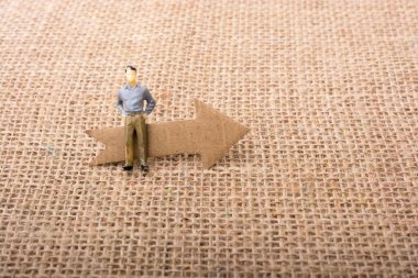 Tablo arkaplanındaki okun yanındaki figür adam