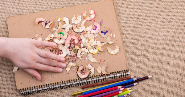 Kahverengi bir arka plan üzerine yerleştirilen renkli kalemler