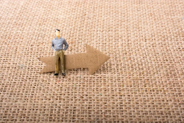 Tablo arkaplanındaki okun yanındaki figür adam