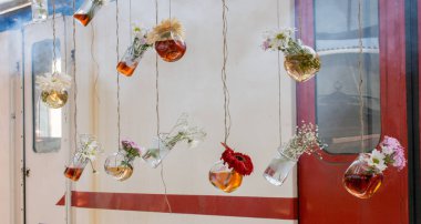 İplere asılı çiçekli bitkisel çay şişeleri