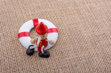 Pinokyo bebeği tuvaldeki can yeleğine bağlı.