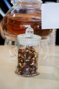 Cam çaydanlıkta demlenmiş bitki çayı ve şişede çay bitkisi.