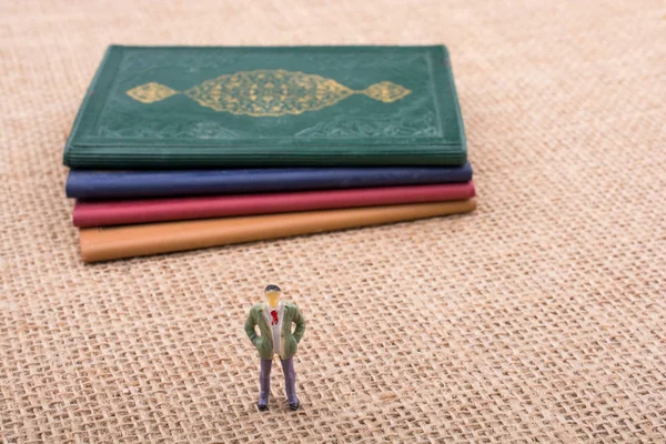 Adam heykelcik ayakta tuval üzerine küçük kitap yanında