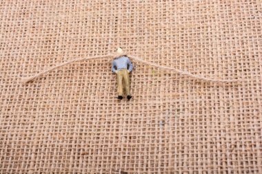 Heykelcik adam boynuna bir ip ile