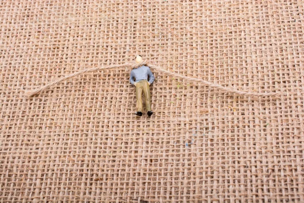 Heykelcik adam boynuna bir ip ile