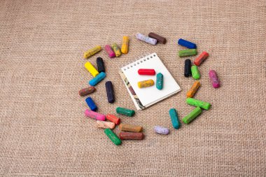 Boya kalemlerinin ortasındaki not defteri.