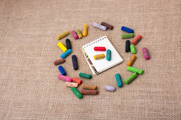 Boya kalemlerinin ortasındaki not defteri.