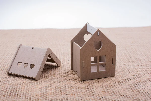 Keten bir tuvale yerleştirilmiş küçük model ev.