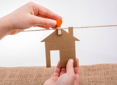 Tuvalin arka planında bir bez evi tutan el.