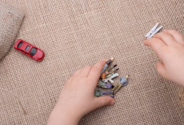 Anahtar, oyuncak arabalar, insan figürleri ve bir tuval üzerine bir torba