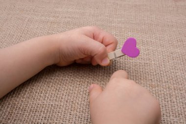 Clothespin el tuval üzerine bir kalp şeklinde nesnesiyle