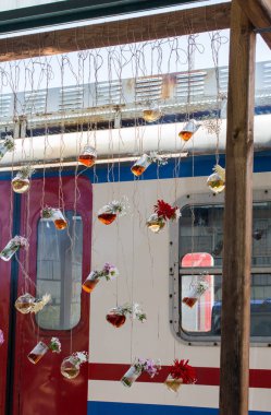 İplere asılı çiçekli bitkisel çay şişeleri