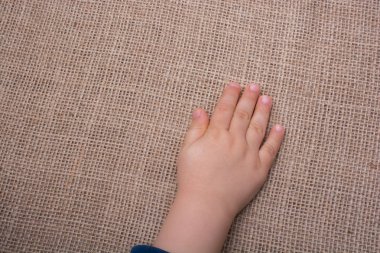 Yürümeye başlayan çocuk el ile keten arka plan bez