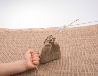 Çarşaftan yapılmış boş bir çuvalı tutan el.