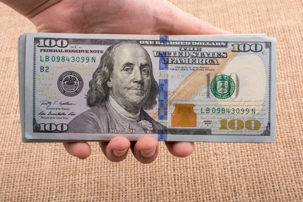 Possédant à la main un paquet de billets en dollars américains — Photo