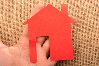 Tuvalin arka planında bir bez evi tutan el.