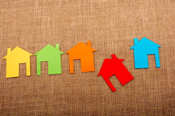 Tuvalin arka planında renkli kağıttan kesilmiş küçük bir ev şekli
