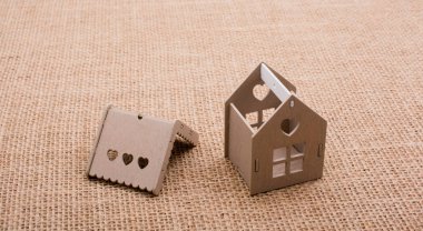 Keten bir tuvale yerleştirilmiş küçük model ev.