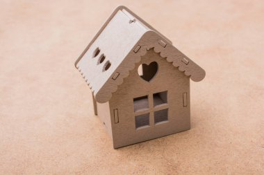 Keten bir tuvale yerleştirilmiş küçük model ev.