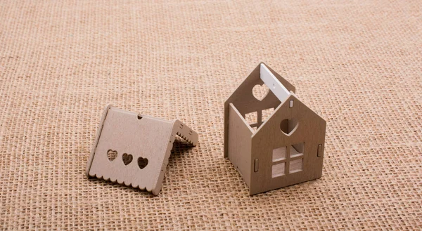 Keten bir tuvale yerleştirilmiş küçük model ev.