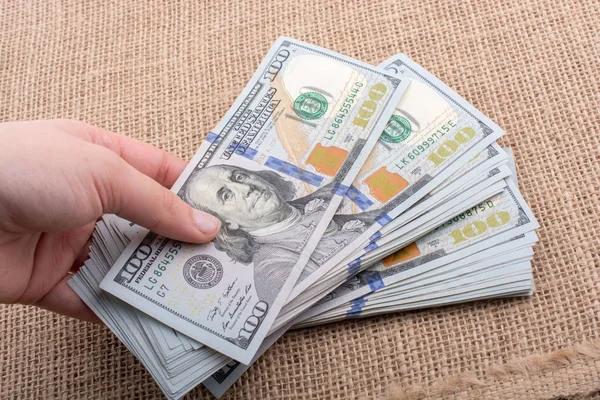 Bize bir paket Doları elinde tutan el