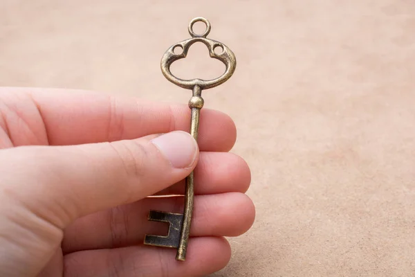 Hand met een retro vormgegeven sleutel — Stockfoto