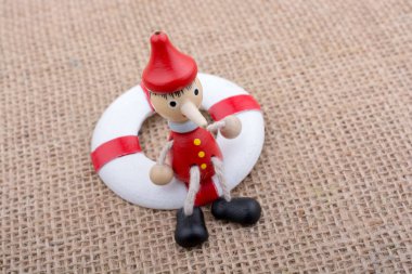 Pinokyo bebeği tuvaldeki can yeleğine bağlı.