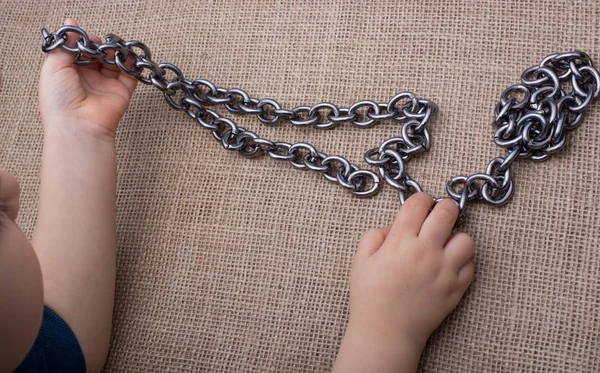 Chain made of metal in hand on canvas — Stock Photo, Image