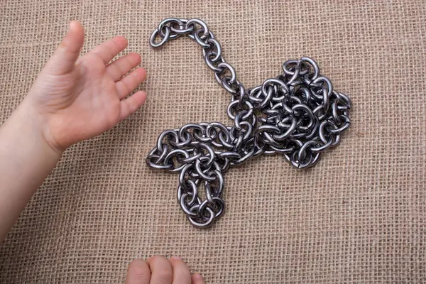 Chain made of metal in hand on canvas — Stock Photo, Image